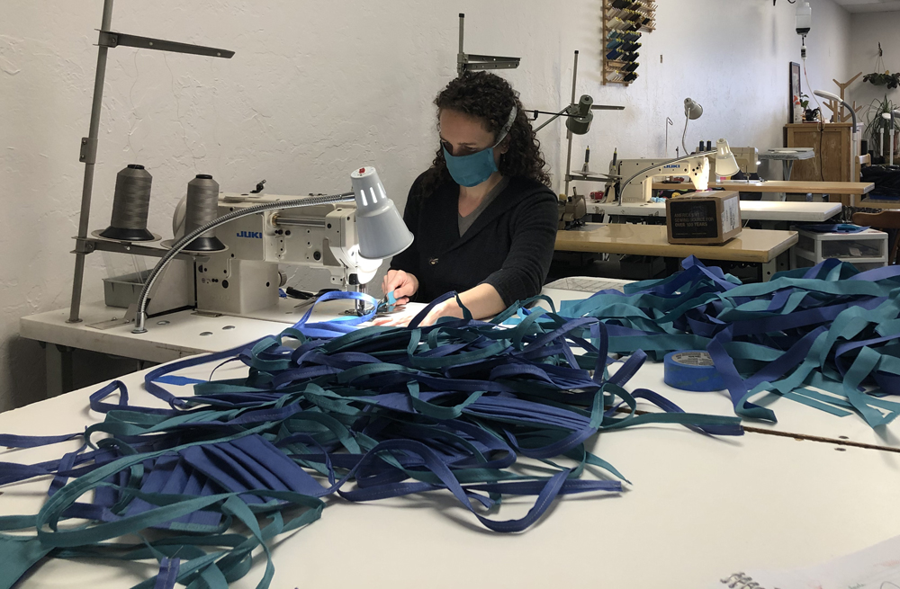 Me binding straps onto a big pile of face masks.