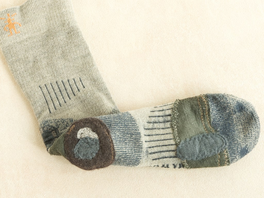 Commercial wool sock with layers of patches and stitching.