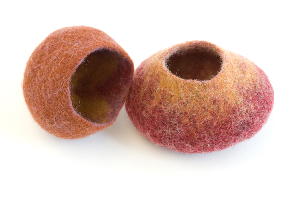 Two small felt bowls, one more open and round, one shorter with a smaller opening